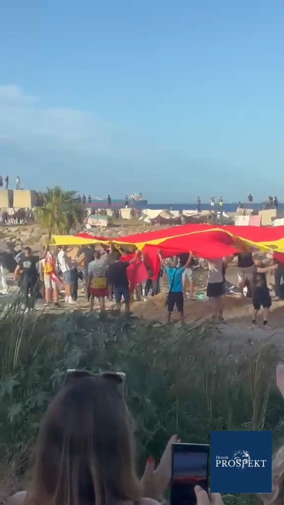 VIDEO Pokrik "Červený kríž von!", obria španielska vlajka na pláži a boje medzi migrantami